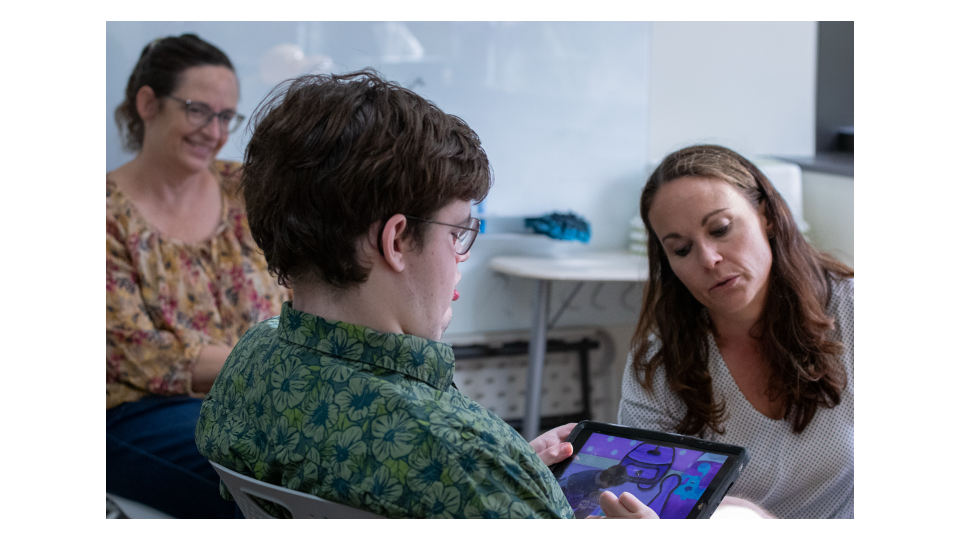A participant and facilitator reviewing a tablet in a healthcare or research setting